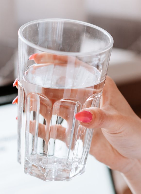 Woman's hand holding a glass of water.